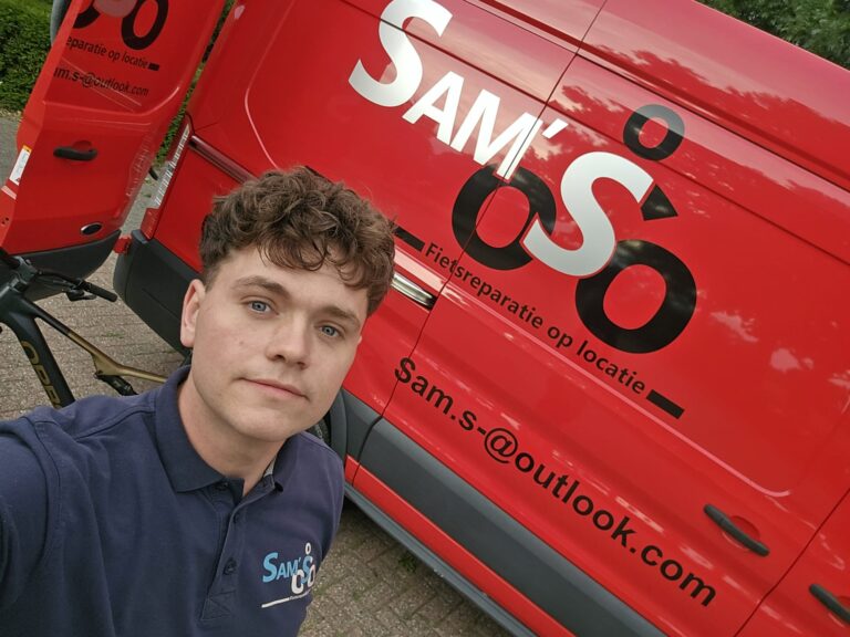 Sam Sleeuwenhoek voor zijn bus met het logo van Sam’s Fietsreparatie